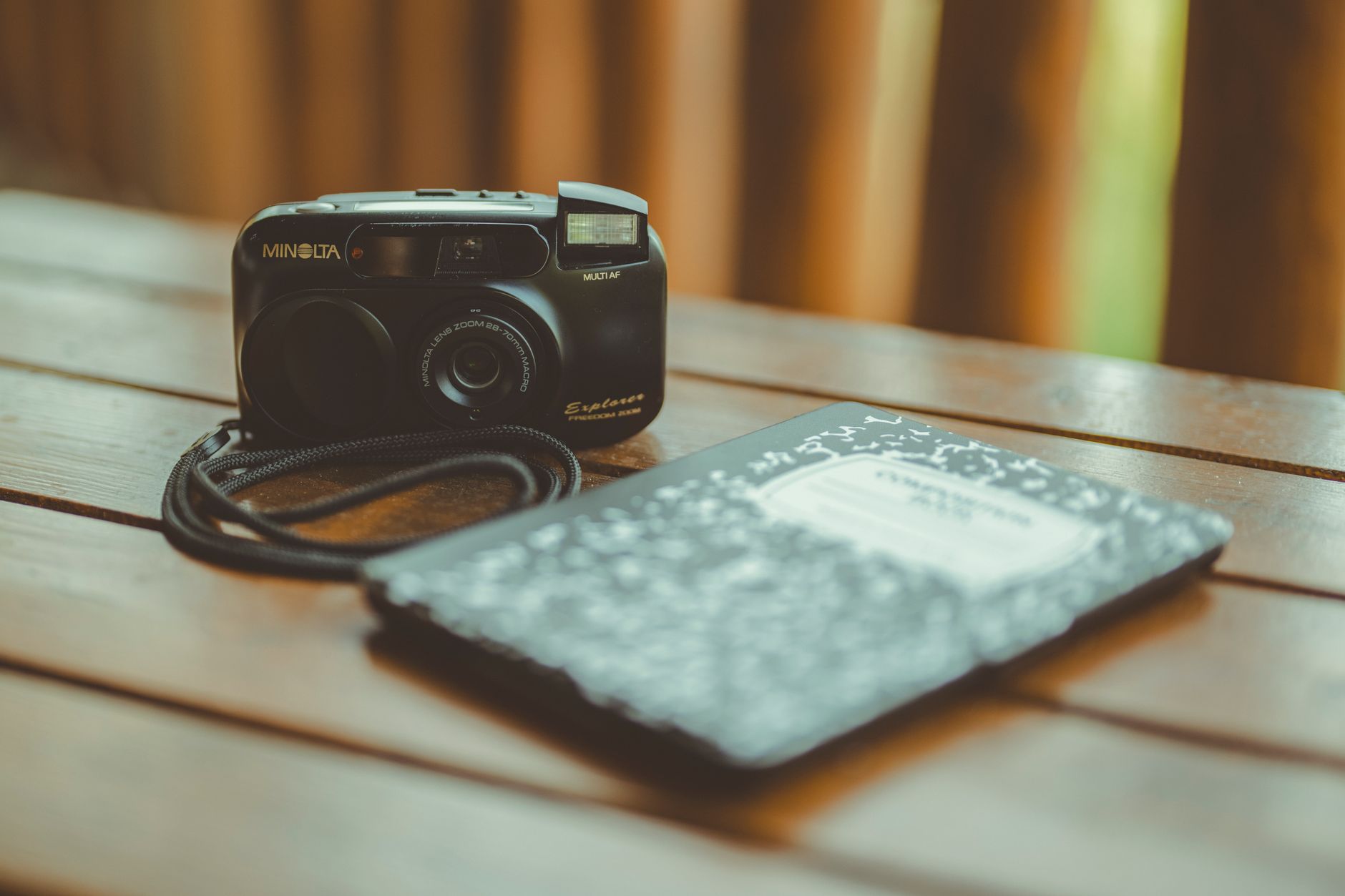 Travel journal and vintage camera on wooden desk